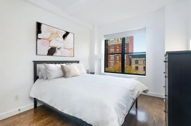 a bedroom with a bed and painting on the wall