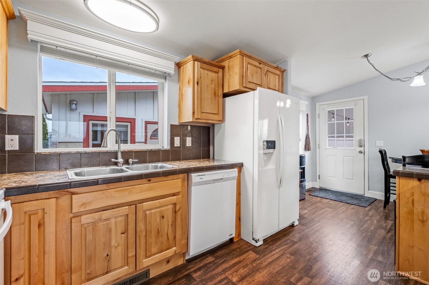 17693 Road 5 Northwest, Unit 52 Quincy, WA 98848 - Photo 10 of 25 a kitchen with stainless steel appliances granite countertop a refrigerator a sink dishwasher and wooden cabinets with wooden floor