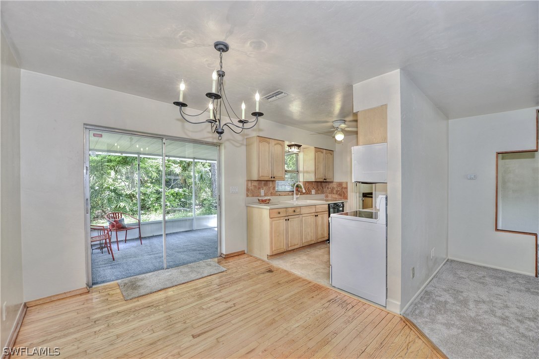9321 Sedgefield Road North Fort Myers, FL 33917 - Photo 4 of 26 a large white kitchen with a refrigerator a stove a sink dishwasher a oven with cabinets and wooden floor