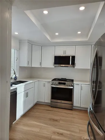 a kitchen with stainless steel appliances a stove a sink and a microwave