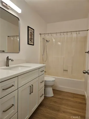 a bathroom with a granite countertop toilet a sink and a bathtub