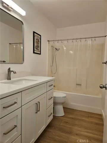 a bathroom with a granite countertop toilet a sink and a bathtub