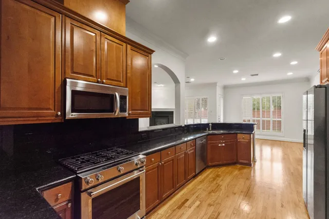 a kitchen with granite countertop a sink a stove and cabinets