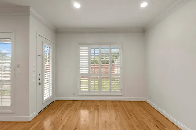 an empty room with windows and chandelier fan