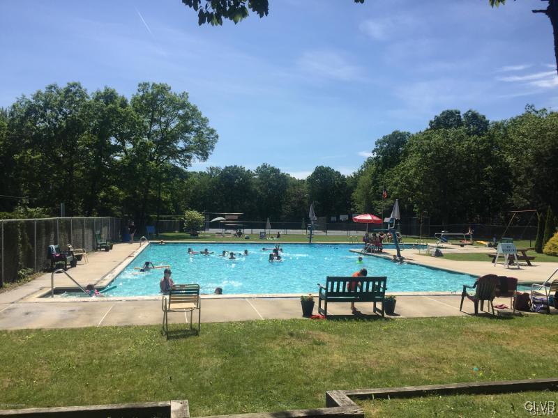 144 Indian Trail Road Jim Thorpe, PA 18229 - Photo 43 of 46 a view of a swimming pool with a bench and trees in the background