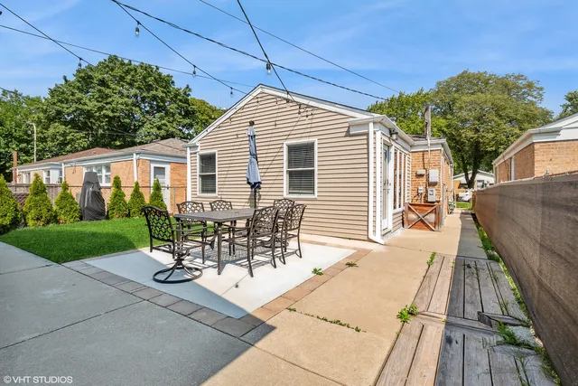 a view of a patio with table and chairs with wooden floor and fence