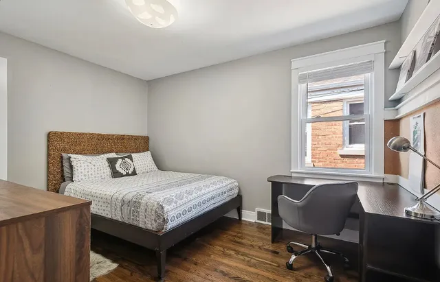 a bedroom with a bed window and a table