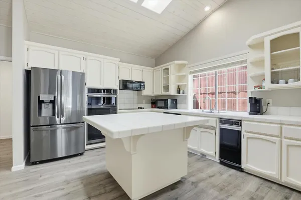 a kitchen with stainless steel appliances granite countertop a stove and a wooden floors