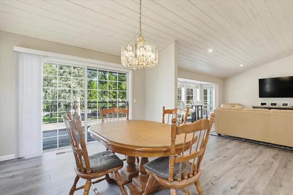 a dining room with furniture a chandelier and wooden floor