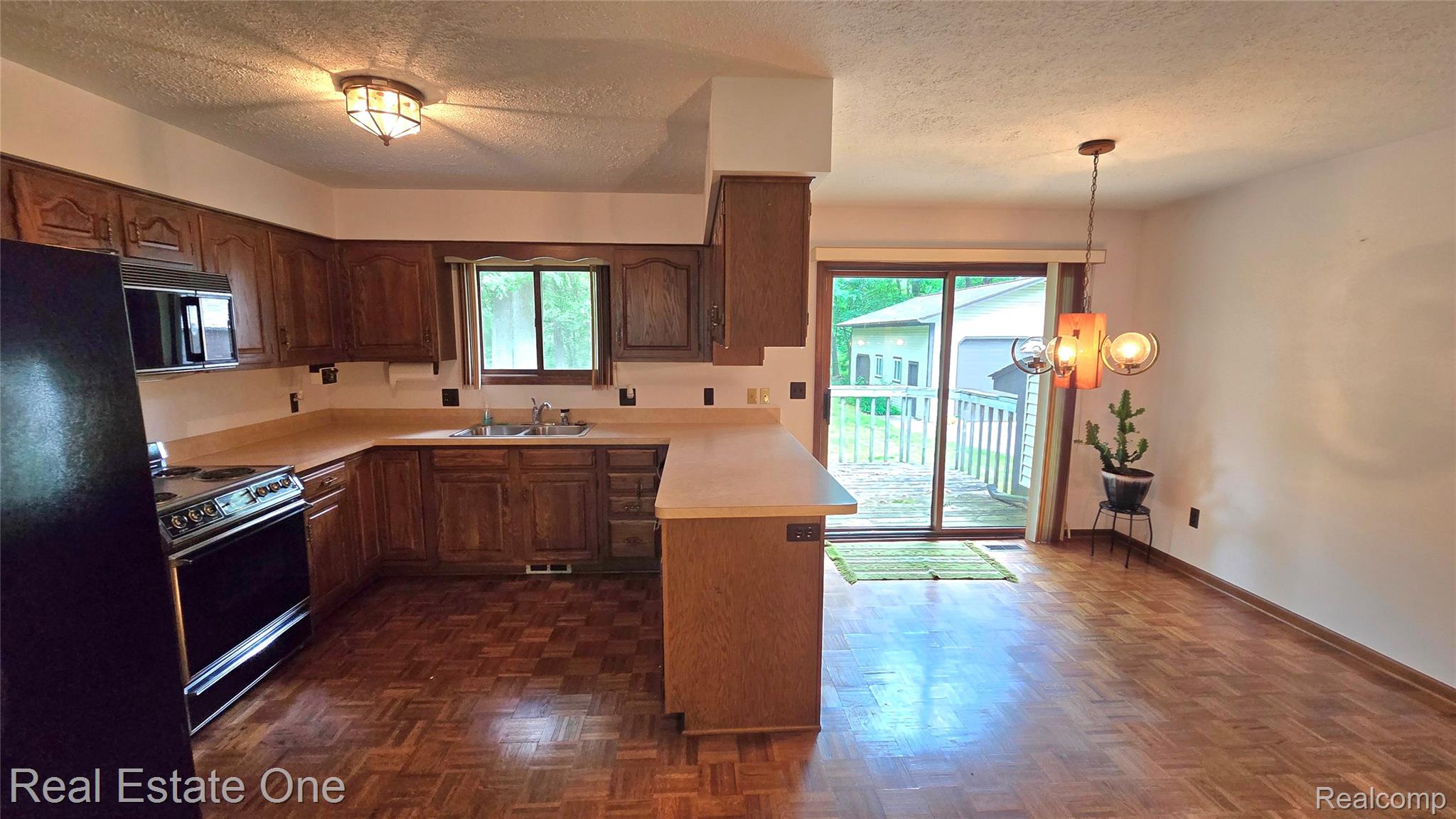 8950 Wise Road Commerce Township, MI 48382 - Photo 12 of 39 Kitchen featuring wood-finish flooring, dark wood cabinetry, and a light-toned countertop