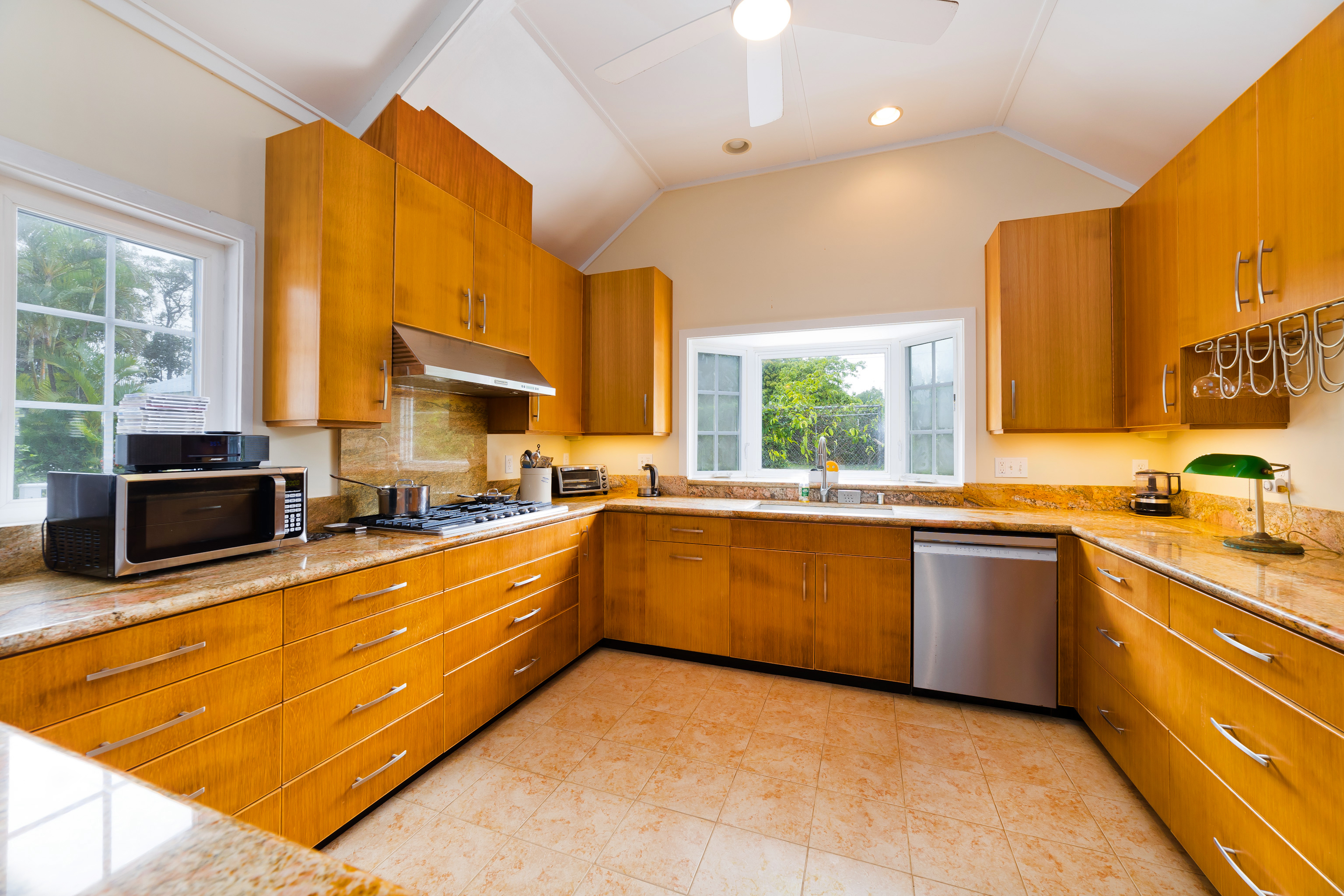 54-333 Union Mill Road Kapaau, HI 96755 - Photo 18 of 30 a large kitchen with stainless steel appliances granite countertop a stove a sink and a microwave
