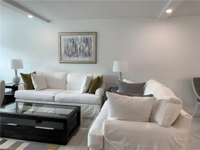 a living room with furniture a couch and painting on the wall