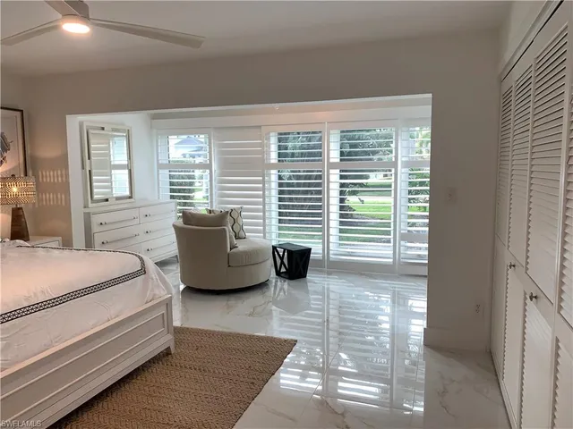 a bedroom with a bed and large window