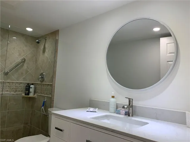 a bathroom with a sink mirror and vanity
