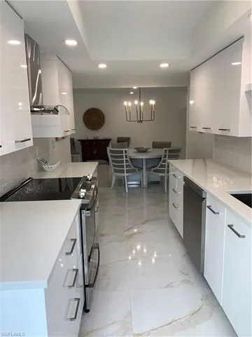 a kitchen with stainless steel appliances a sink a stove and a wooden floors