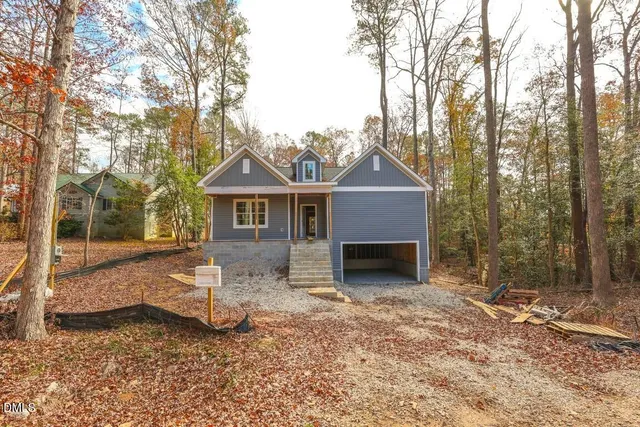 a front view of a house with a yard covered in snow