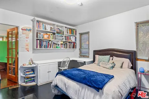a bedroom with a bed and a book shelf