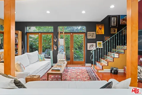 a living room with large window and furniture