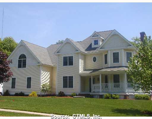 a front view of a house with a yard and trees