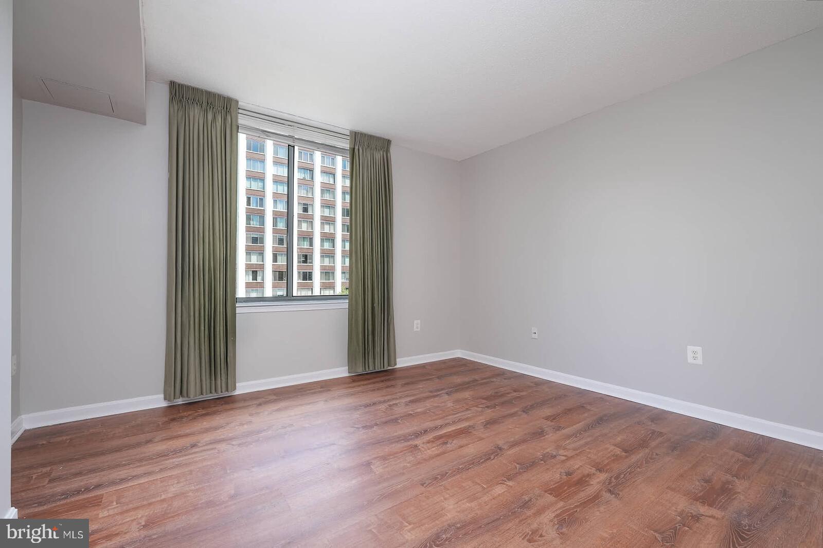 11710 Old Georgetown Road, Unit 429 North Bethesda, MD 20852 - Photo 12 of 40 a view of an empty room with wooden floor and a window