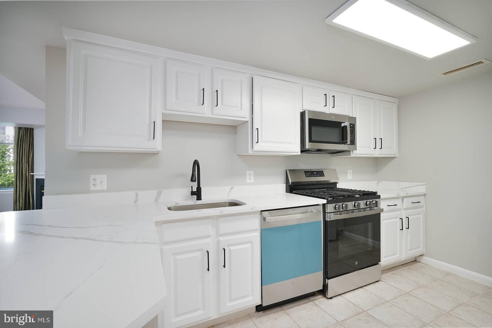 11710 Old Georgetown Road, Unit 429 North Bethesda, MD 20852 - Photo 4 of 40 a kitchen with white cabinets stainless steel appliances and sink