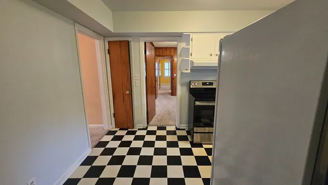 a view of an empty room with a fireplace and a window