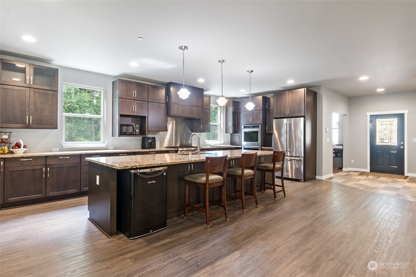 7101 Vandermark Road East Bonney Lake, WA 98391 - Photo 5 of 39 a large kitchen with lots of counter space dining table and stainless steel appliances