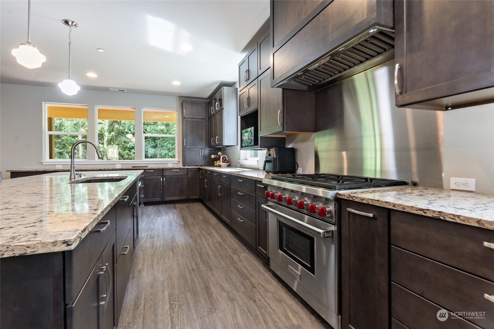7101 Vandermark Road East Bonney Lake, WA 98391 - Photo 6 of 39 a kitchen with stainless steel appliances granite countertop a stove a sink and a wooden floors