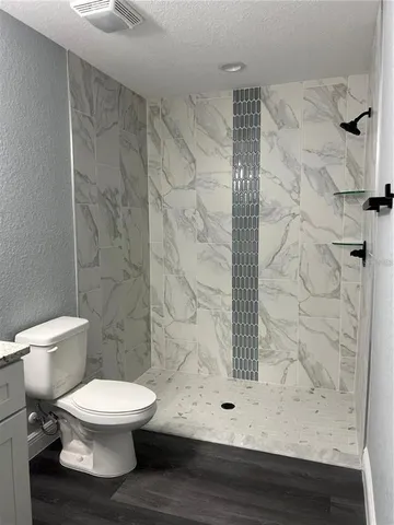 a white toilet sitting next to a shower