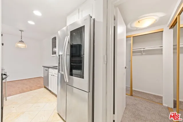 a view of a hallway with wooden floor and a bathroom