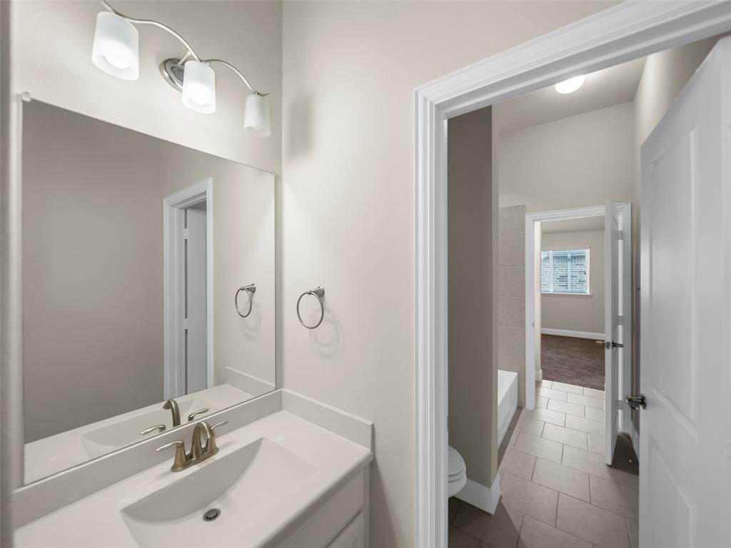 3044 Bold Ruler Road Celina, TX 75009 - Photo 16 of 36 a bathroom with a sink and a mirror