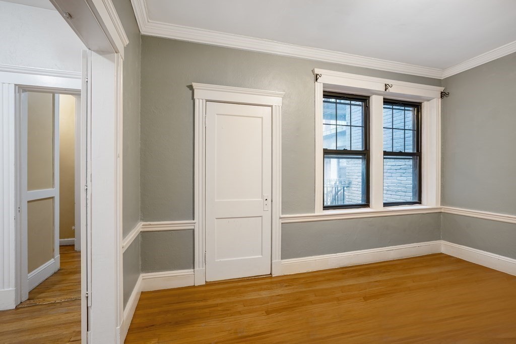 59 Lanark Road, Unit 2 Boston, MA 02135 - Photo 3 of 18 a view of an empty room with wooden floor and a window