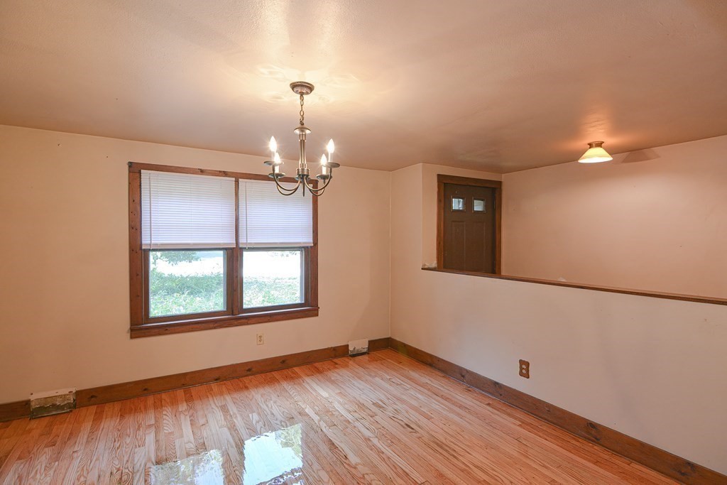 69 Stafford Road Holland, MA 01521 - Photo 5 of 27 an empty room with wooden floor chandelier and windows