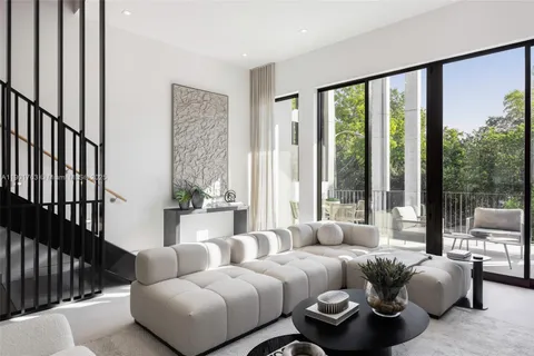 a bedroom with furniture and large windows