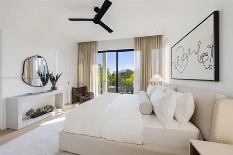a large white bed sitting in a room next to a window