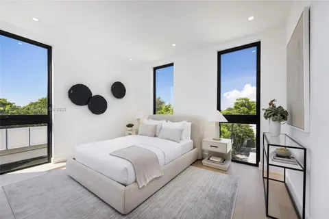 a bedroom with a bed and a large mirror with the potted plant