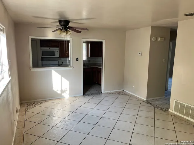 a view of an empty room with window and cabinet