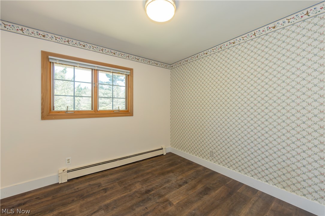 7969 Dines Road Novelty, OH 44072 - Photo 29 of 48 Bedroom featuring wood-finish flooring, a window with wood trim, and baseboard heating
