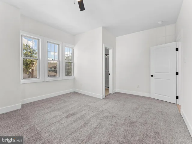 an empty room with windows and closet