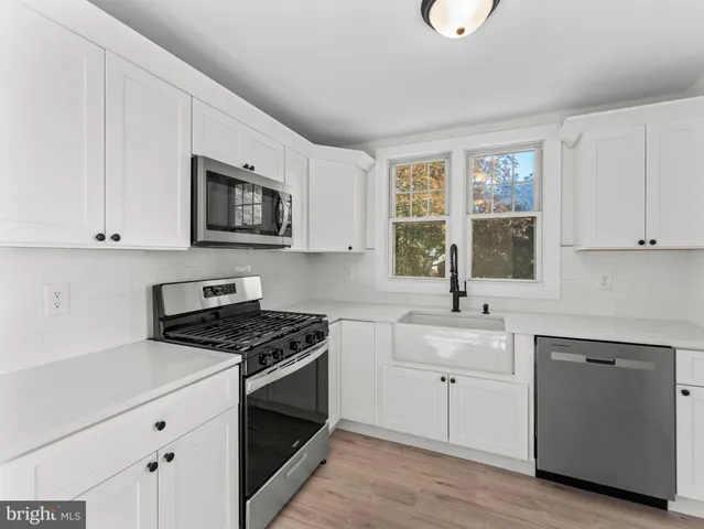 a kitchen with cabinets appliances a sink and a window