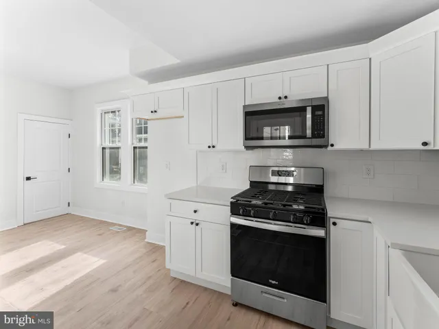 a kitchen with cabinets stainless steel appliances and wooden floor