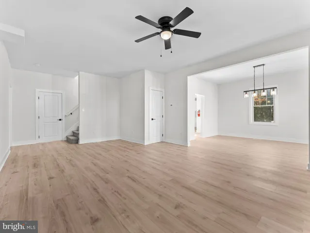 a view of empty room with wooden floor and ceiling fan