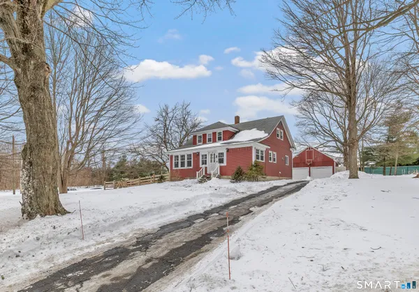 a front view of a house with a yard covered in snow