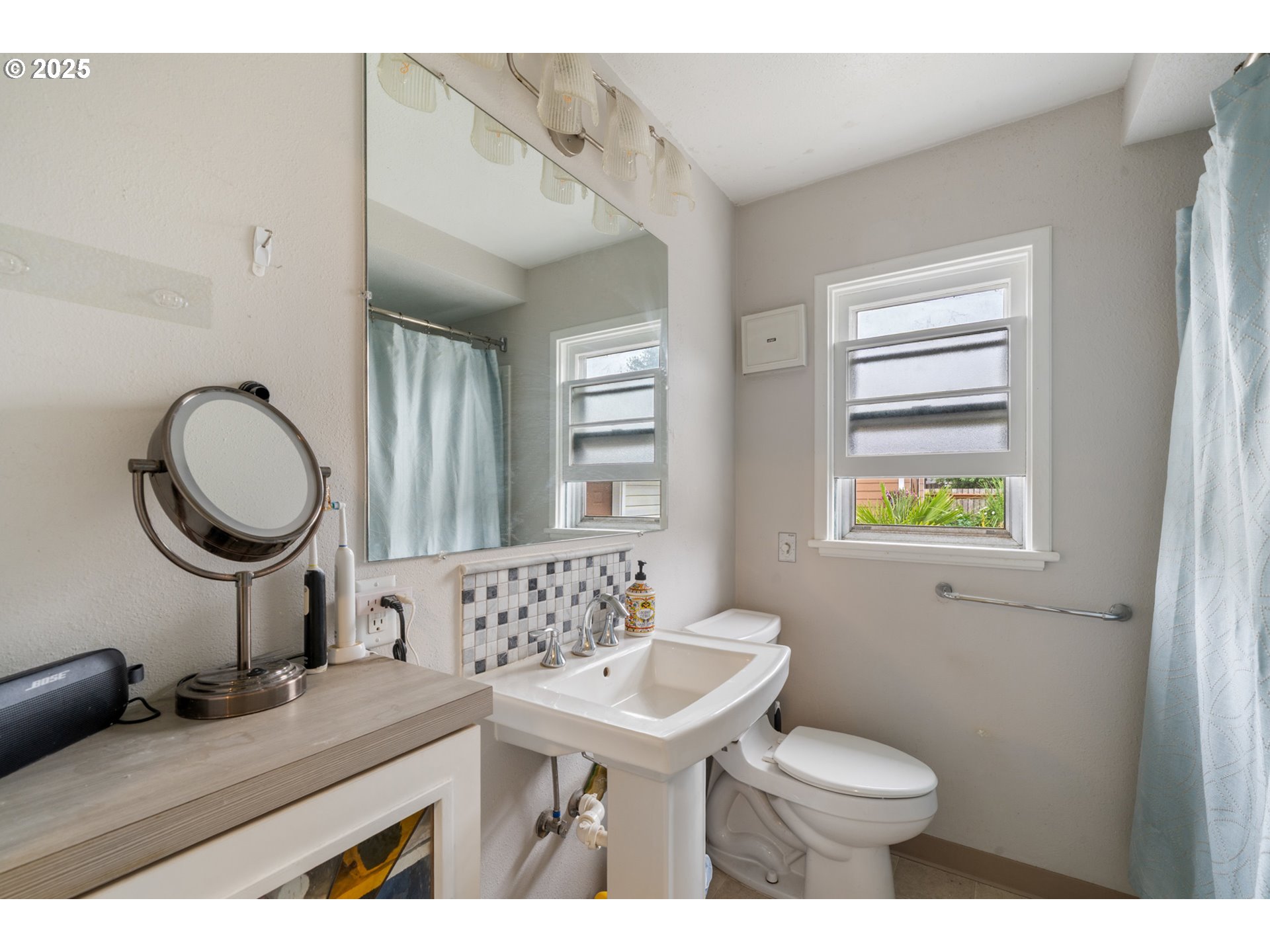 1706 5th Street Tillamook, OR 97141 - Photo 10 of 29 a bathroom with a toilet a sink and a mirror