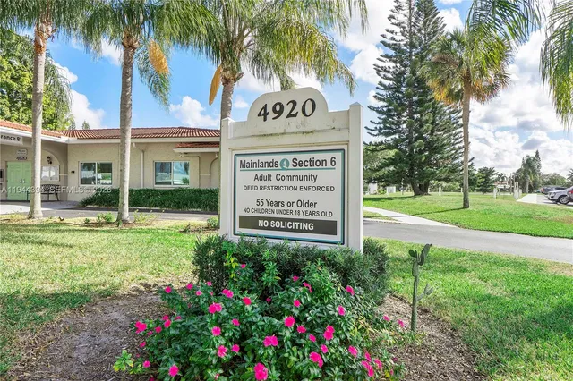 a view of a house with a yard and potted plants
