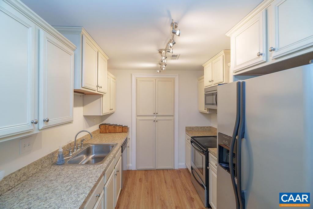 2976 Cove Trace Charlottesville, VA 22911 - Photo 41 of 62 a kitchen with granite countertop a refrigerator a sink and wooden cabinets