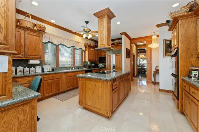 a kitchen with stainless steel appliances kitchen island granite countertop a stove a sink dishwasher and a refrigerator