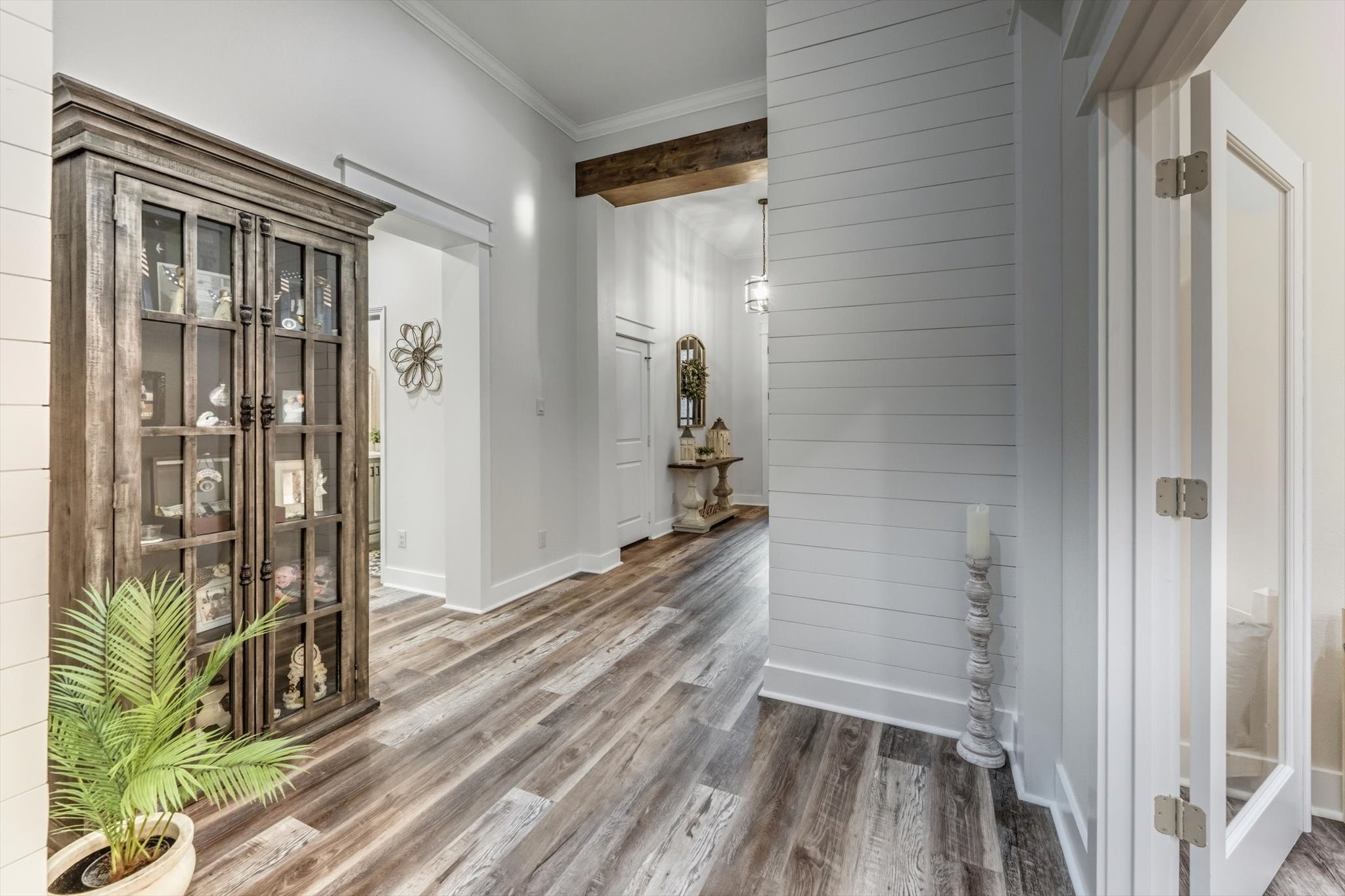 103 Fox Rindle Road Montgomery, TX 77316 - Photo 24 of 44 The grand central hallway offers a beautifully designed transition to the private quarters, study, and secondary bedrooms, highlighted by warm wood flooring and custom ceiling beam detail.