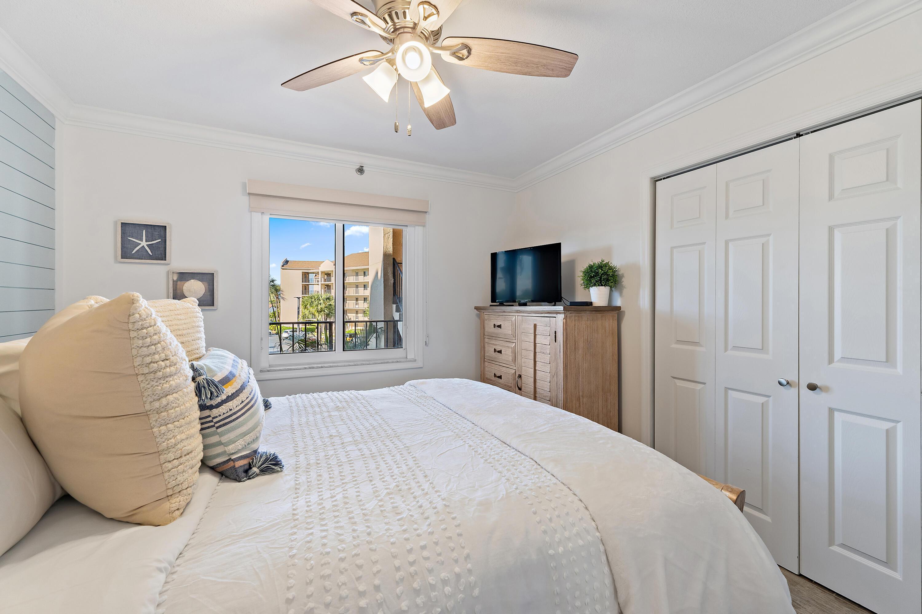 275 Palm Avenue, Unit A301 Jupiter, FL 33477 - Photo 11 of 38 a bedroom with a bed and a flat tv screen on dresser
