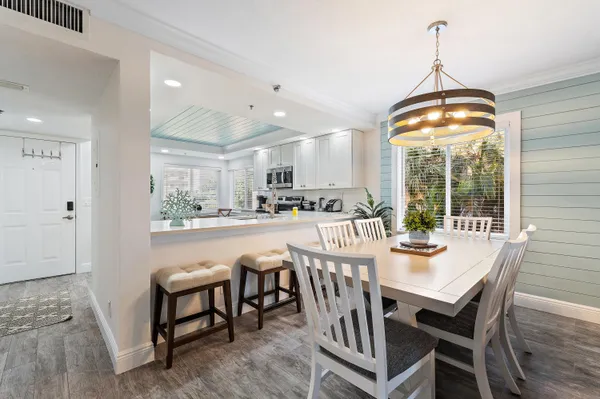 a dining room with furniture a chandelier and wooden floor